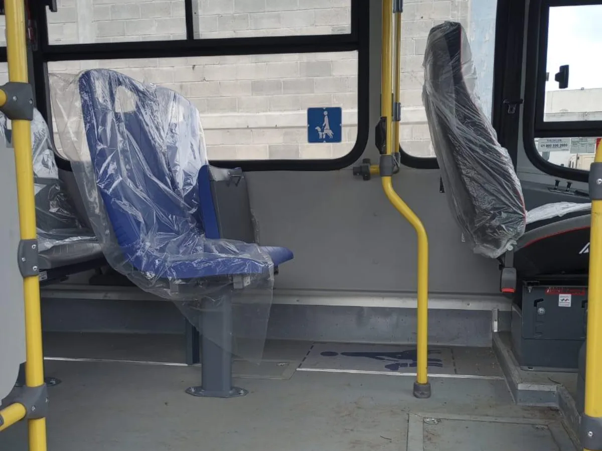 Espacio interior señalizado con pictograma de silla de ruedas, junto a un asiento abatible.