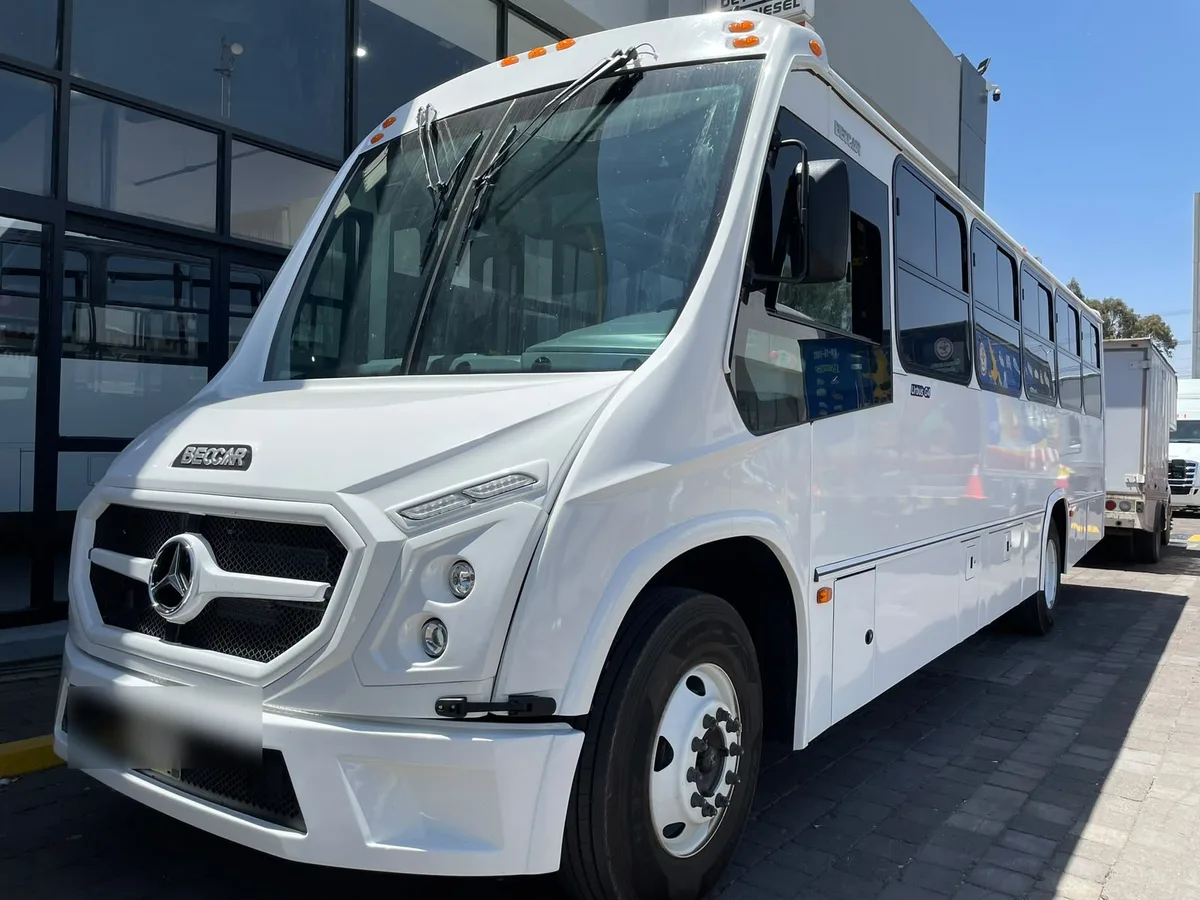 Autobús Mercedes-Benz blanco con carrocería Beccar, completo y de tres cuartos frontal.