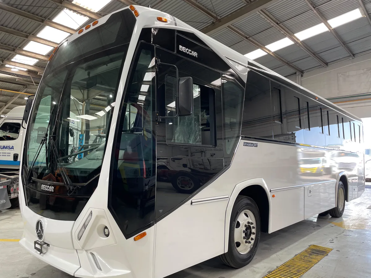 Autobús Beccar Urviabus MT blanco de parabrisas panorámico, completo, de tres cuartos frontal.